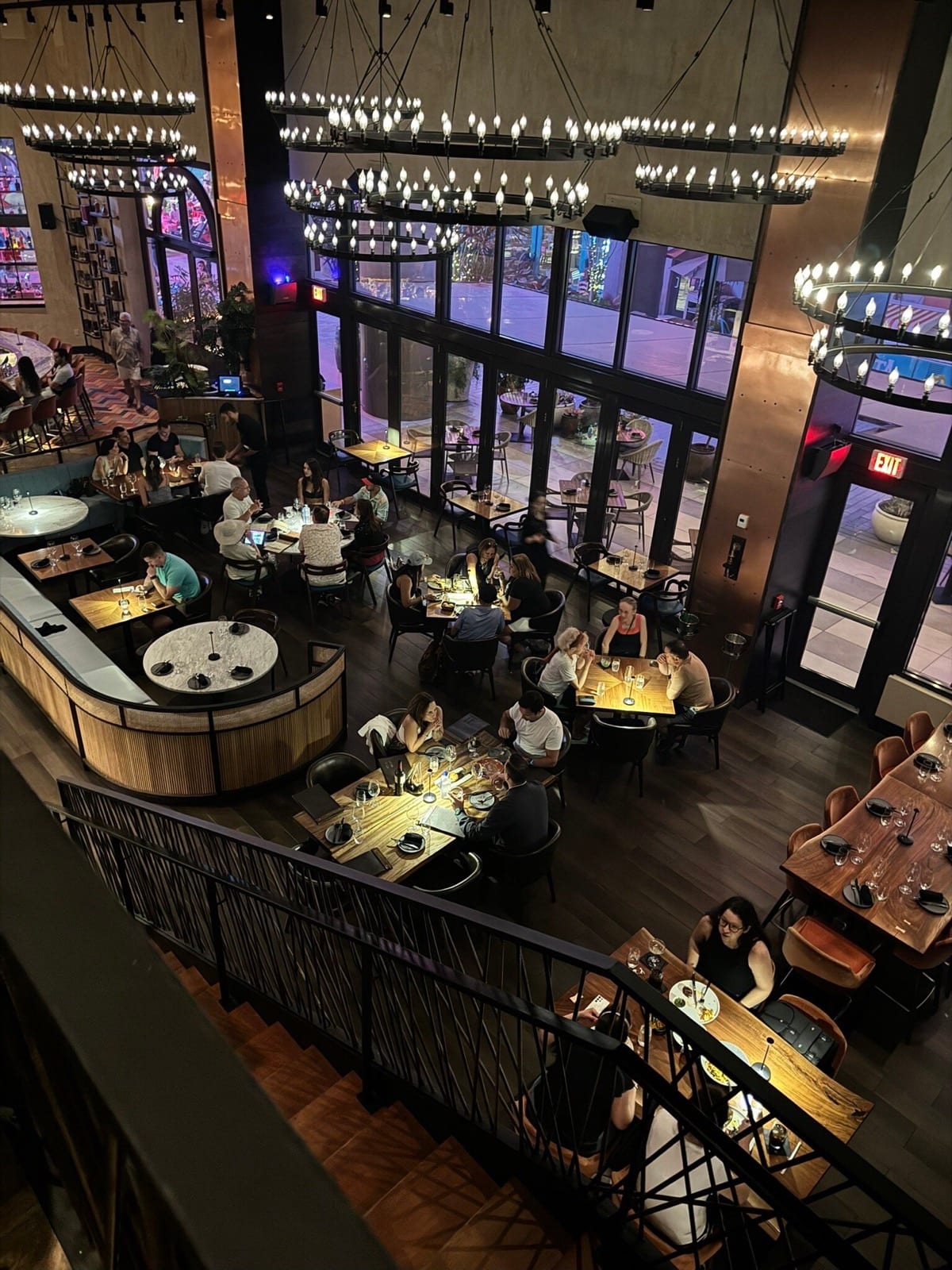 Interior de restaurante fine dining con mesas y luces colgantes.